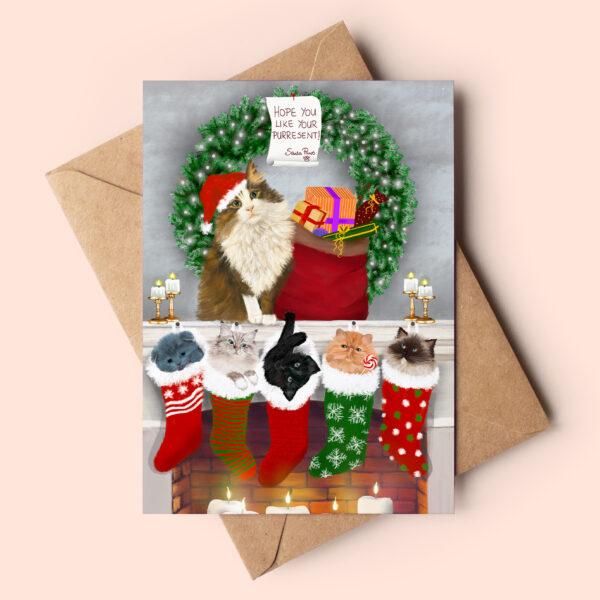 Christmas card showing a brown and white turkish angora cat sitting on the mantle wearing a santa hat. Below him there are various kittens in christmas stockings hanging over the fireplace. The card reads: Hope you like your purresent! Santa Paws.
