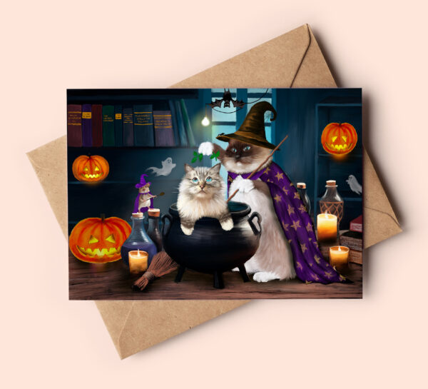 Cute halloween card featuring a ragdoll cat sitting in a cauldron and another one wearing a witch's hat and cape.