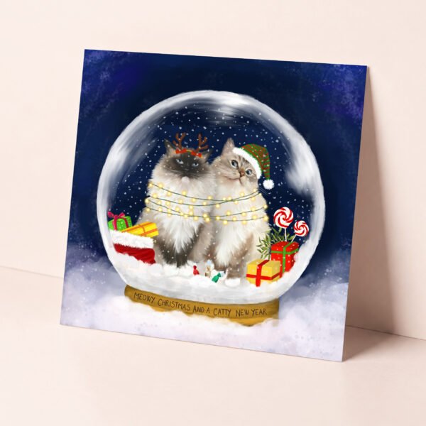 Magical christmas card featuring two festive ragdoll cats in a snow globe.