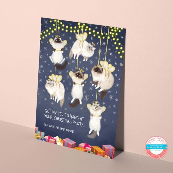 Ragdoll Christmas card featuring fluffy cats dressed as angels hanging humorously as decorations.