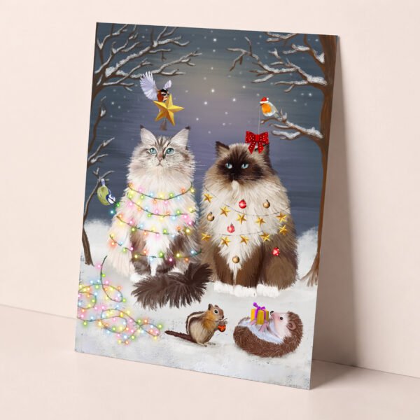 Magical ragdoll cat christmas card featuring two fluffy cats in a snowy winter forest being surrounded by cute forest animals.